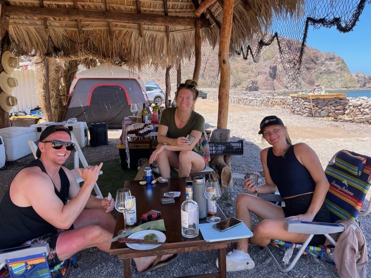 Guests at a beachside palapa table in Baja